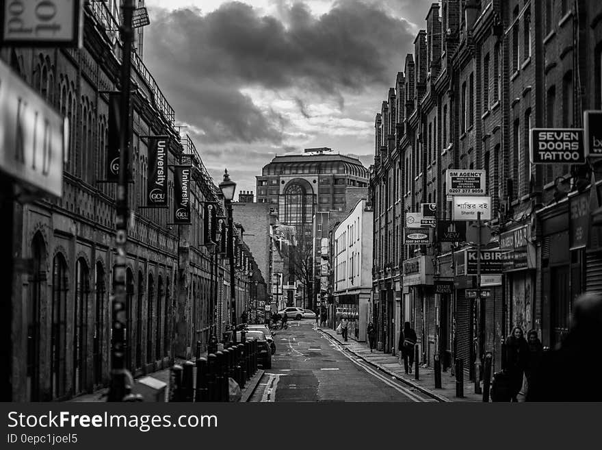 Black and White Photo of Street and Builldings With People