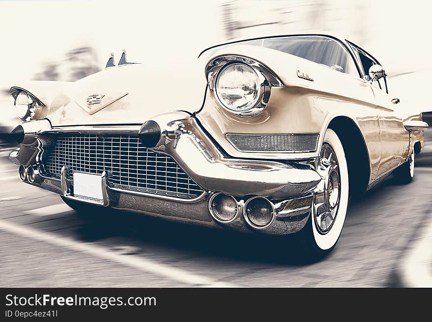 Close up of front fender and headlights on vintage tan car in parking space. Close up of front fender and headlights on vintage tan car in parking space.