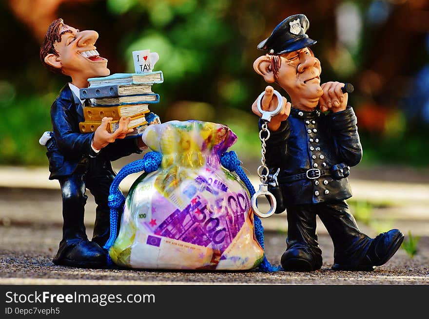 Toy figures of a policeman and an official with sack of money, corruption concept. Toy figures of a policeman and an official with sack of money, corruption concept.