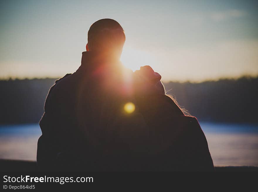 A couple watching sunset or sunrise together.