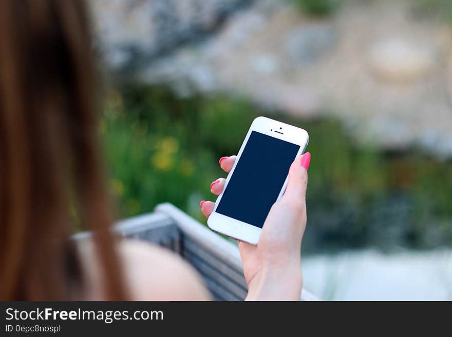 A close up of a woman holding a smartphone in her hand. A close up of a woman holding a smartphone in her hand.