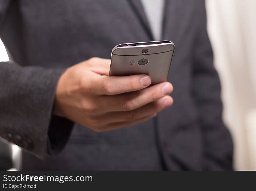 Man Wearing Black Suit Jacket Holding Gray Htc Android Smartphone