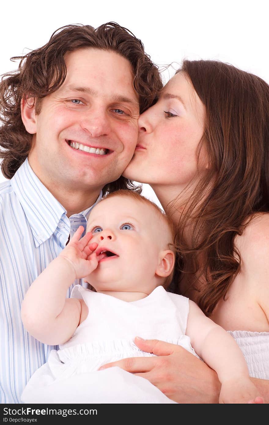 Brown Haired Woman Kissing Man in Blue White Dress Shirt Holding Baby in White Dress