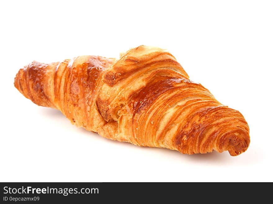 French croissant, a breakfast pastry, eaten with coffee, perfectly baked, white background.