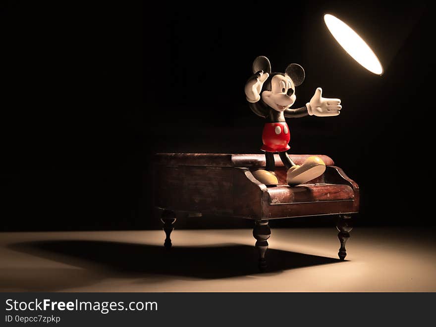 3d Mickey Mouse character dancing on piano under spotlight. 3d Mickey Mouse character dancing on piano under spotlight.