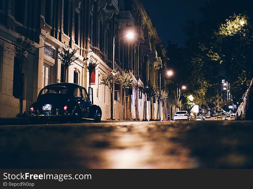 Black car parked in street in Istanbul, Turkey, with illuminated historic buildings at night, black sky background. Black car parked in street in Istanbul, Turkey, with illuminated historic buildings at night, black sky background.