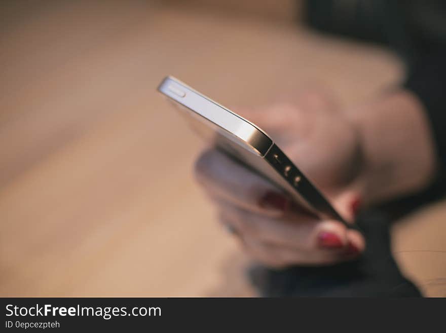 Close up of hand holding and using smartphone indoors. Close up of hand holding and using smartphone indoors.