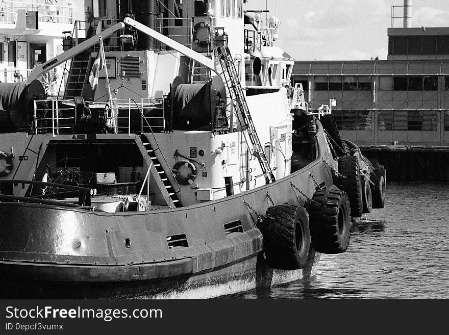 A black and white photo of a fishing boat in a harbor.