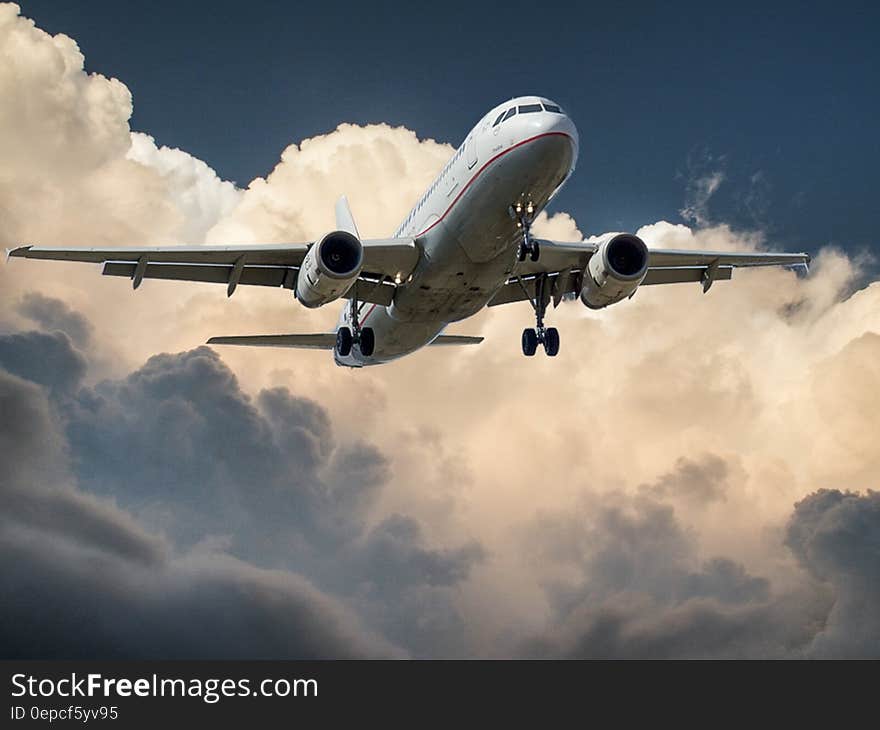 An airplane ready for landing, white clouds in the background. An airplane ready for landing, white clouds in the background.