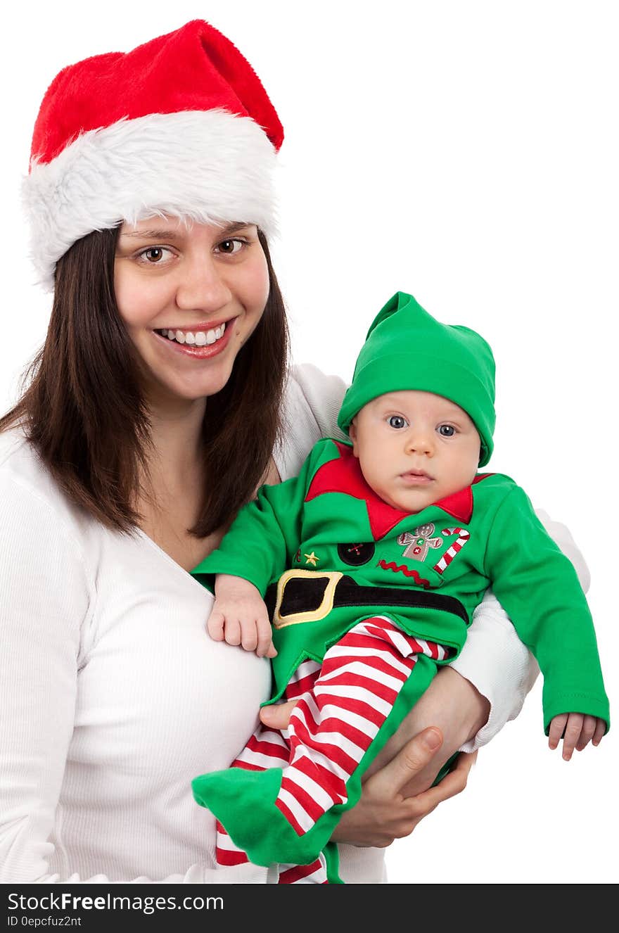 Smiling Woman Wearing Santa Hat Carring Baby Wearing Elf Costume