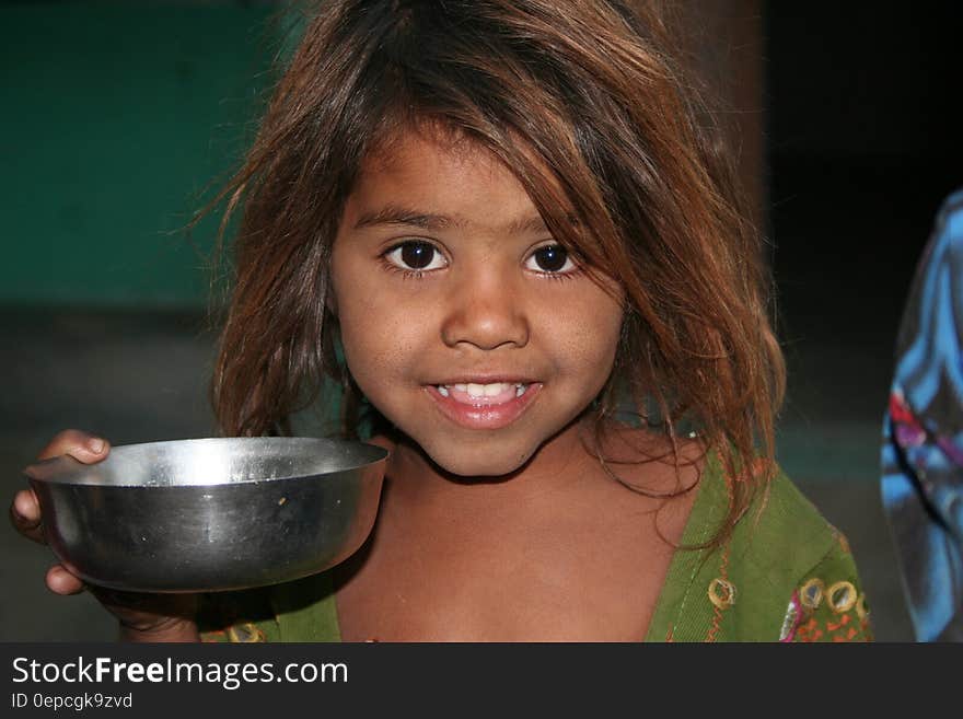 Girls on Green Shirt Holding a Silver Round Bowl