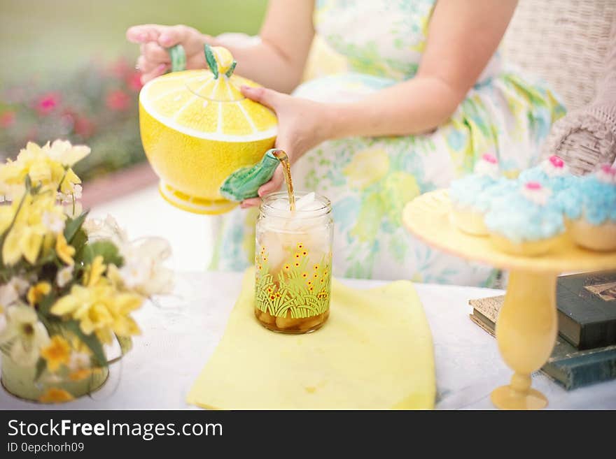 Person Holding Yellow and Green Lime Shape Ceramic Tea Pot