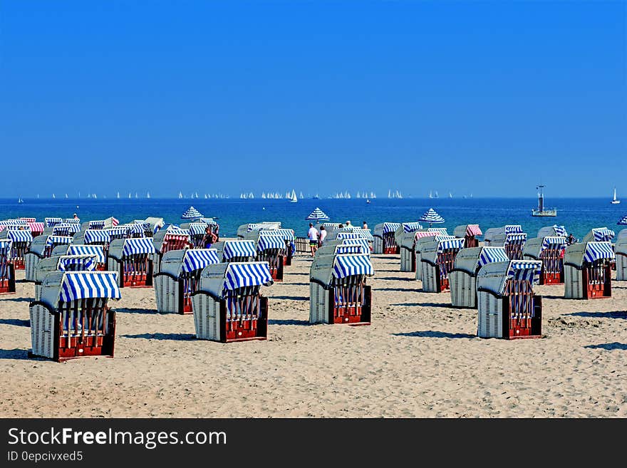 Folded chairs on sandy beach along blue waters of Baltic Sea on sunny day. Folded chairs on sandy beach along blue waters of Baltic Sea on sunny day.