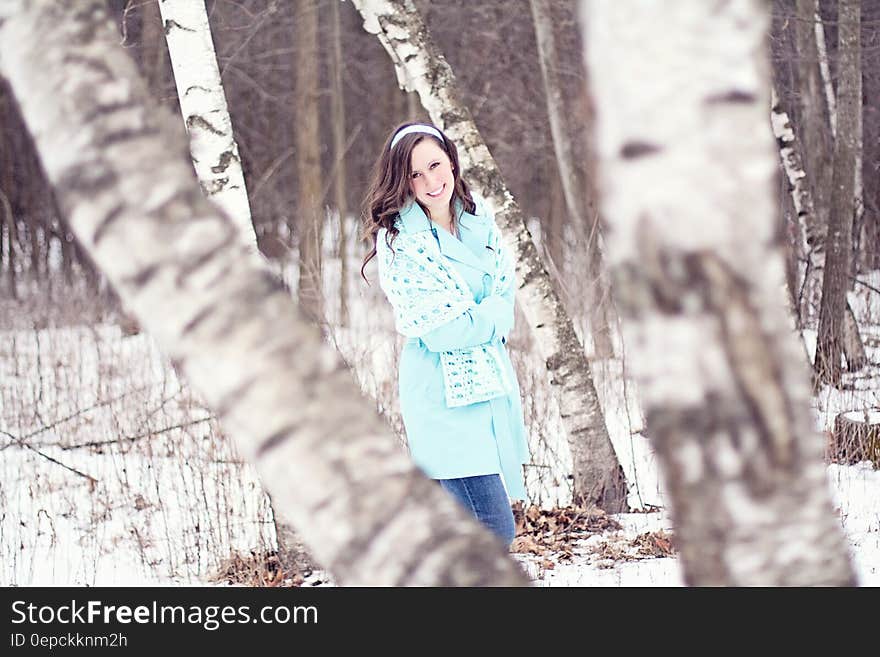 Smiling young girl walking though snow covered wintry forest. Smiling young girl walking though snow covered wintry forest.