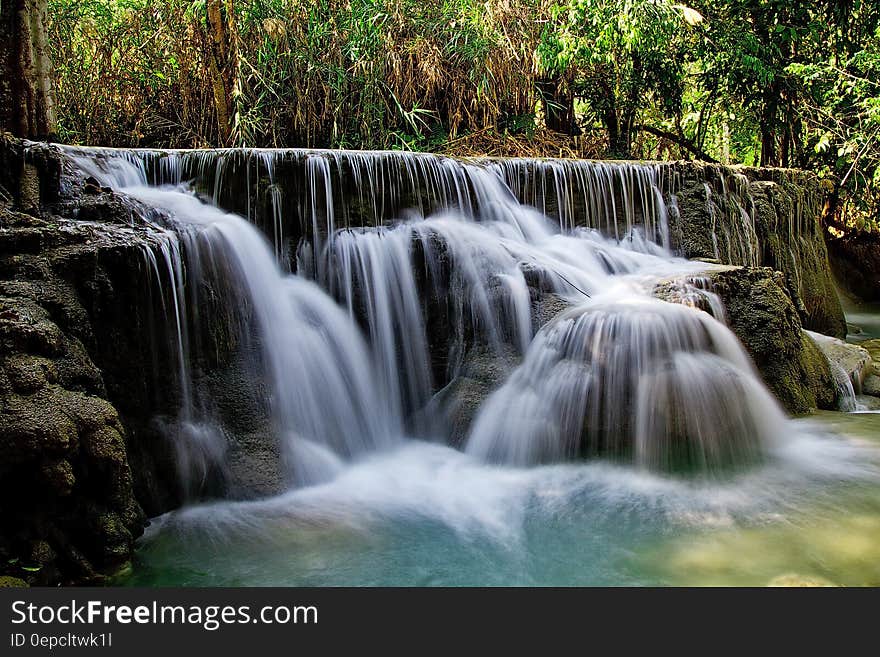 A long exposure of a waterfall cascading down the rocks in a forest. A long exposure of a waterfall cascading down the rocks in a forest.