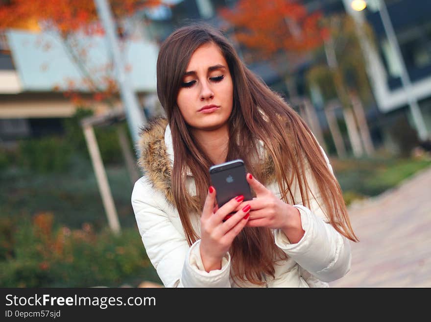 A woman using her smartphone outdoors. A woman using her smartphone outdoors.