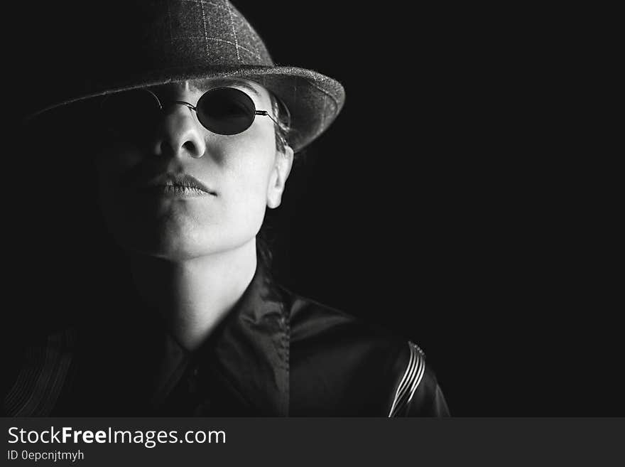 Studio portrait of Asian man in hat and dark sunglasses on black background. Studio portrait of Asian man in hat and dark sunglasses on black background.