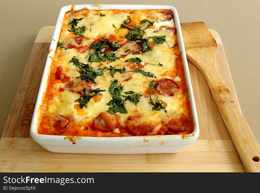 A baked tomato and sausage casserole with cheese on top. A baked tomato and sausage casserole with cheese on top.