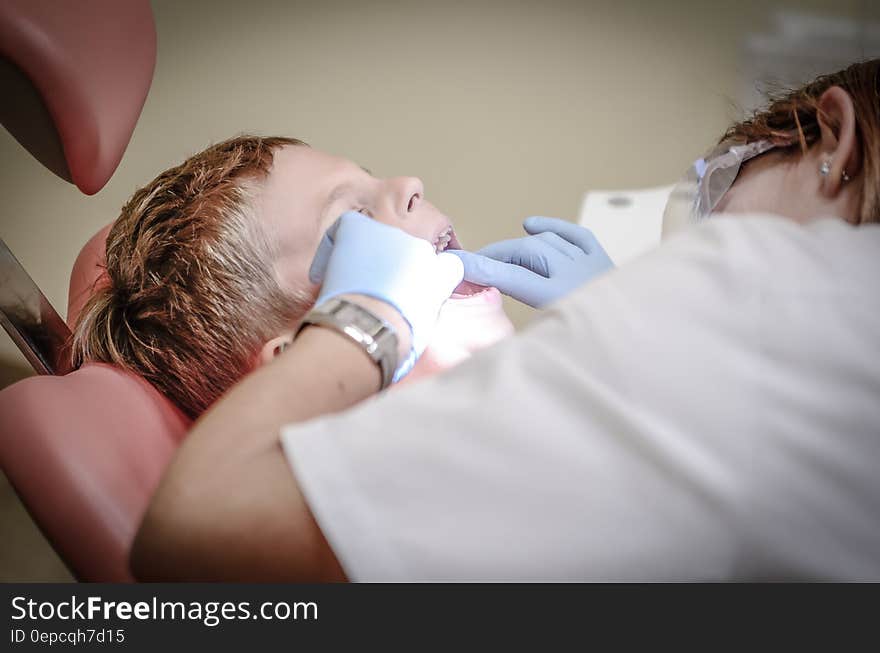 Dentist Woman Wearing White Gloves and White Scrubsuit Checking Boy&#x27;s Teeth