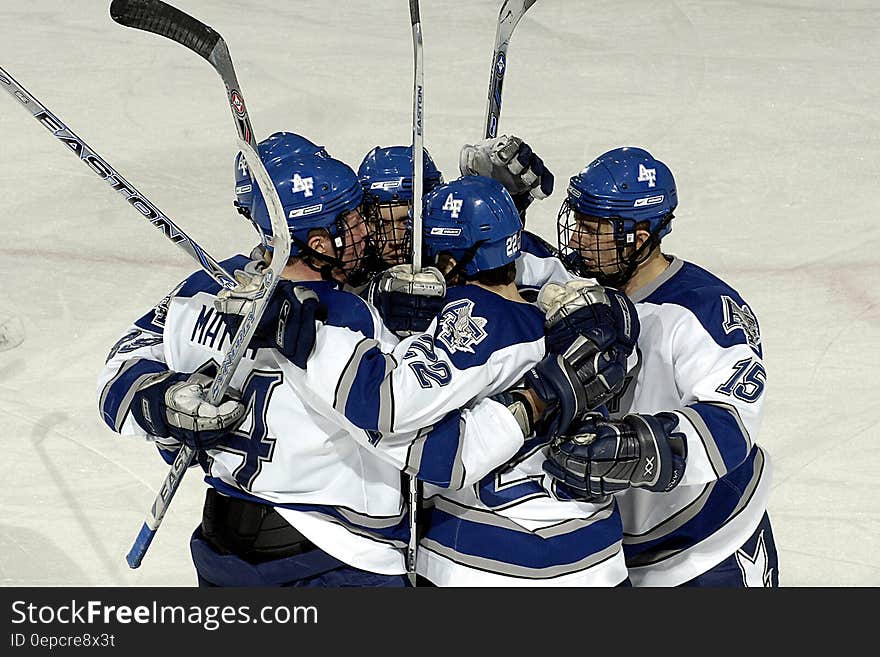 Hockey team celebrating or huddling on ice.