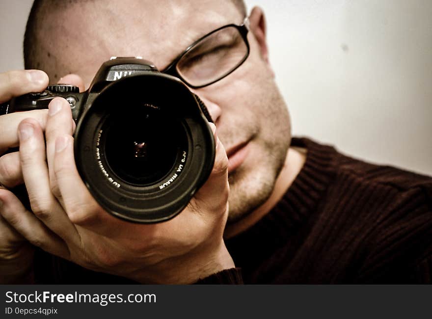 A photographer taking a selfie with a DSLR through a mirror. A photographer taking a selfie with a DSLR through a mirror.