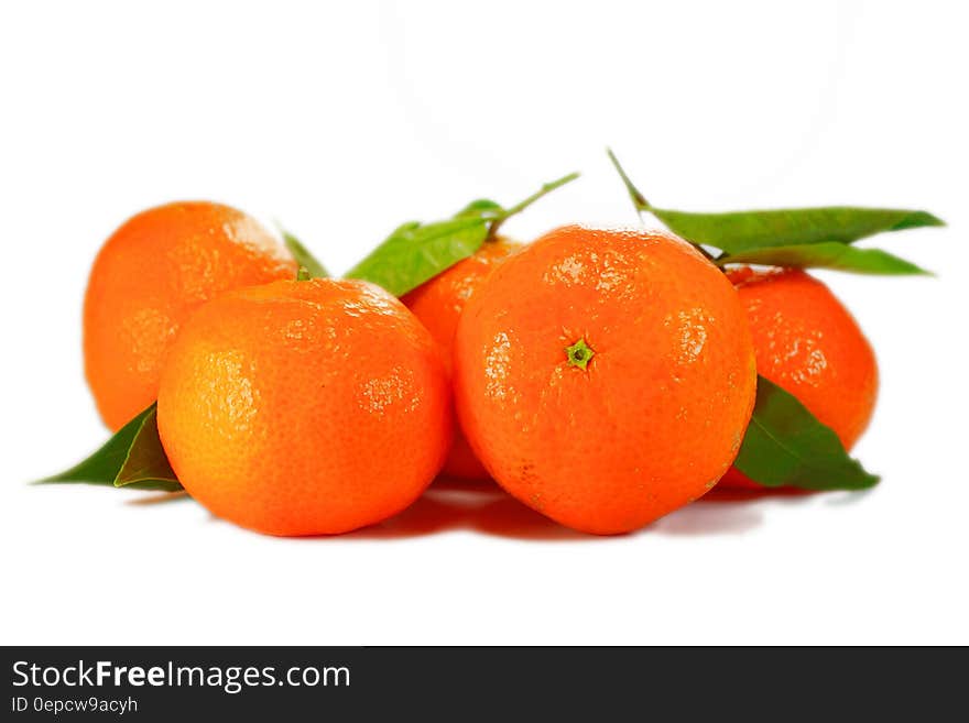 Close up of whole oranges and green leaves isolated on white. Close up of whole oranges and green leaves isolated on white.