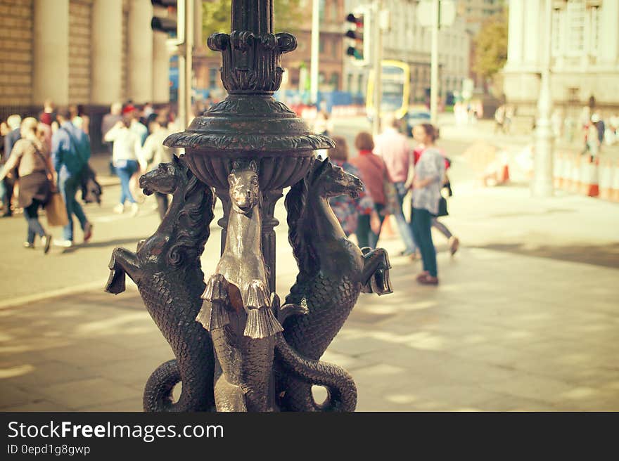 Gold seahorse statue in city square on sunny day.