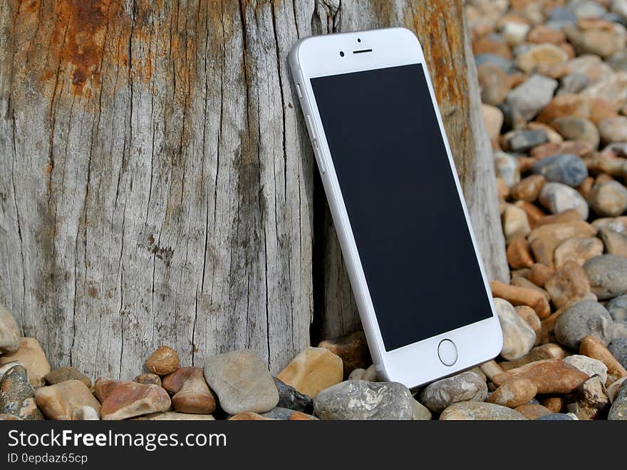 Silver Iphone 6 on Gray and Brown Stone