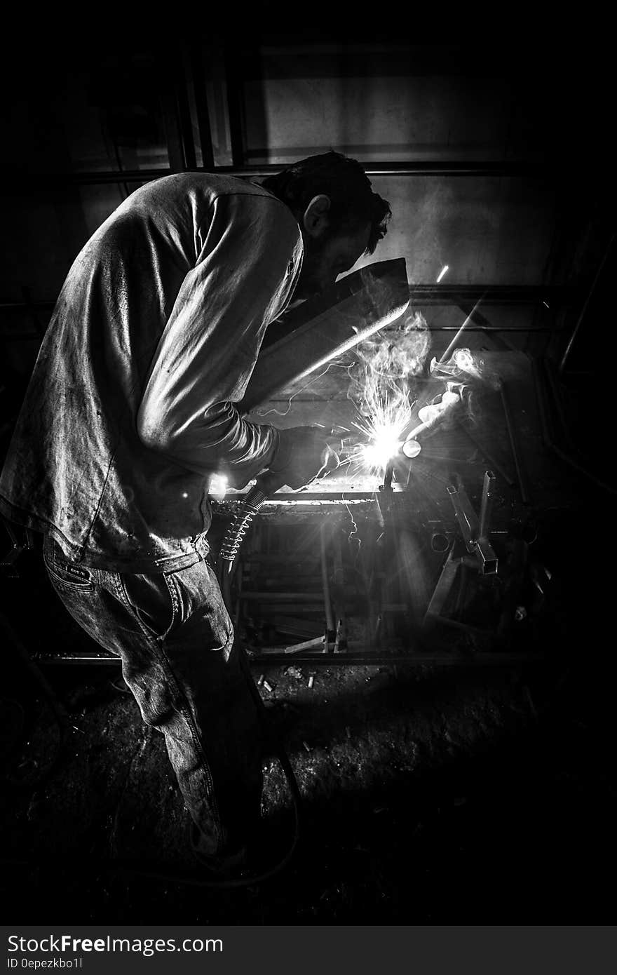 Greyscale Photo of Person Having Welding