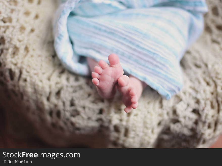 Baby Feet Underneath a Blue Blanket