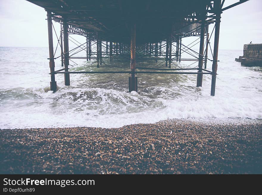 Brown Sand Beside Seashore and Wave of Water during Day Time