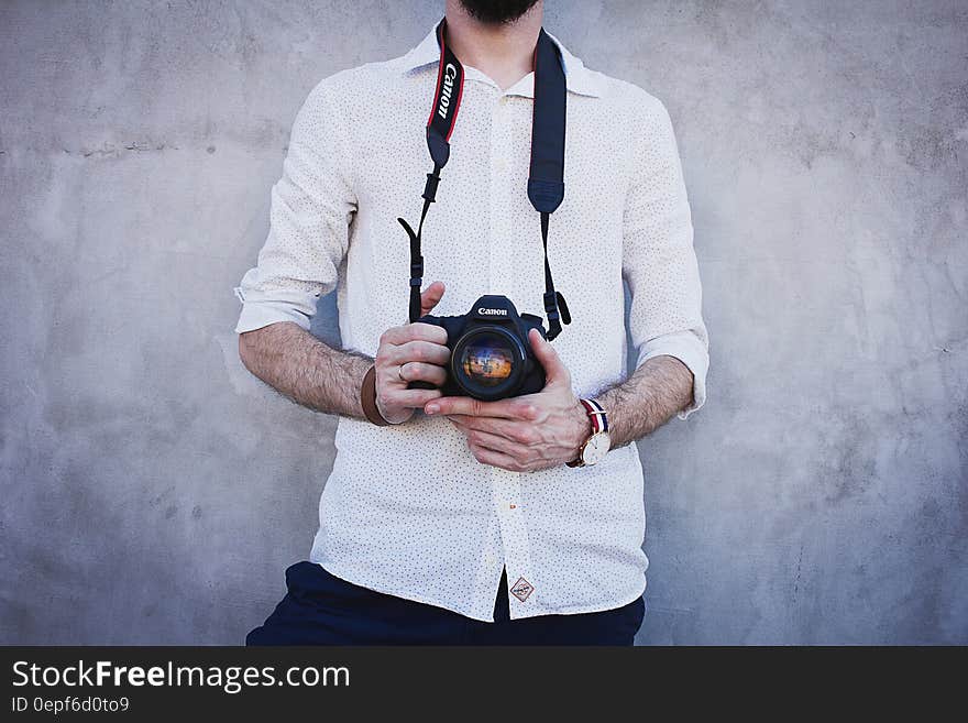 Man Wearing White Long Sleeves Holding Black Canon Dslr Camera