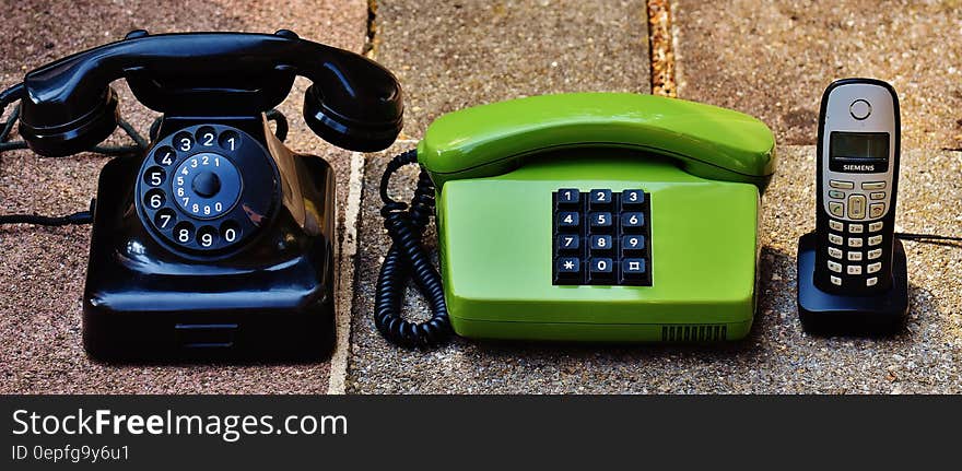 Collection of vintage land line phones on stone walk. Collection of vintage land line phones on stone walk.