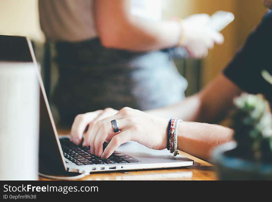 Person With Grey Ring Using Macbook Pro