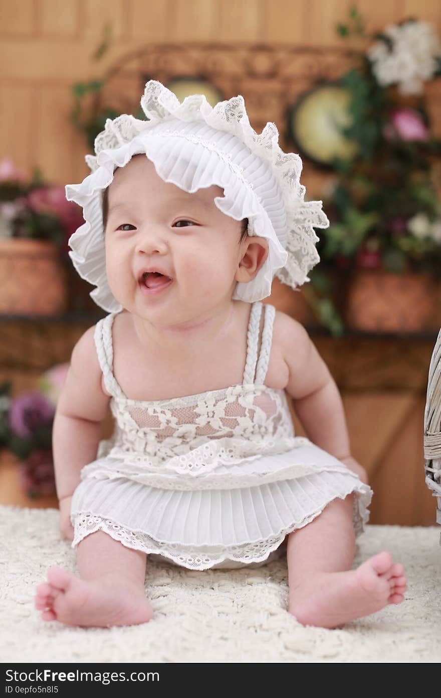 Baby in White Dress With White Headdress