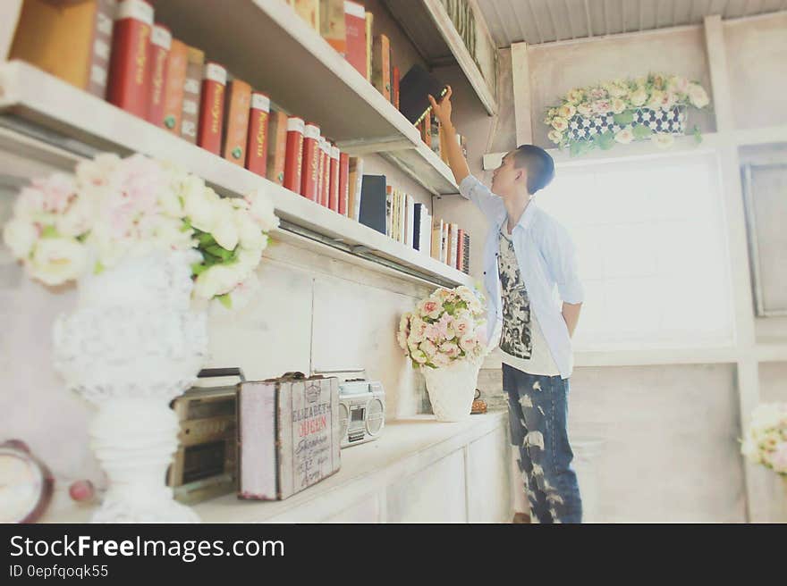 Man takes book off shelf