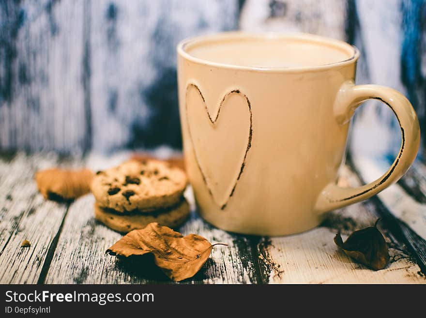 Beige Ceramic Heart Mug With Coffee Beside Cookie Food