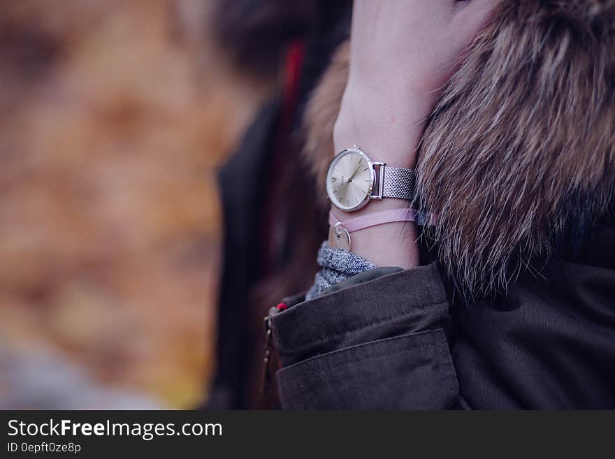 Woman in Brown Parka Jacket With Gold Round Analog Watch