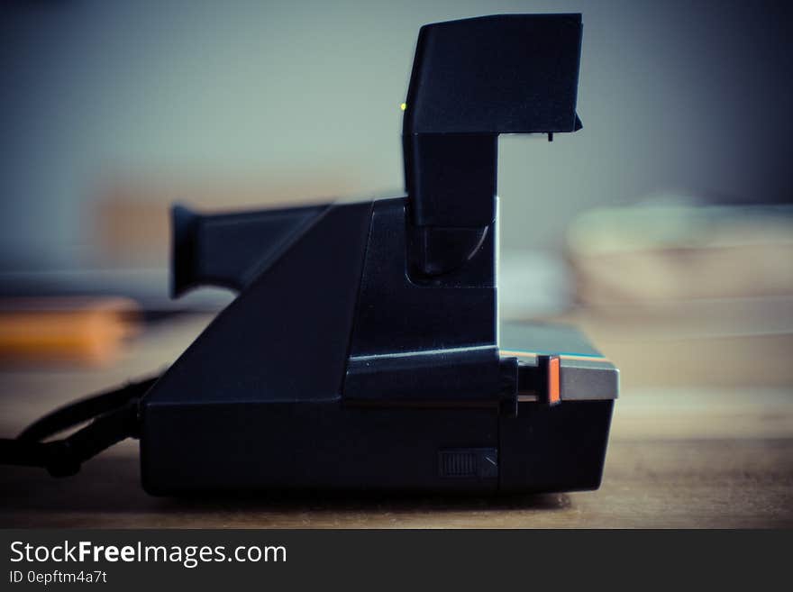 Black and Gray Instant Camera on Brown Wooden Table