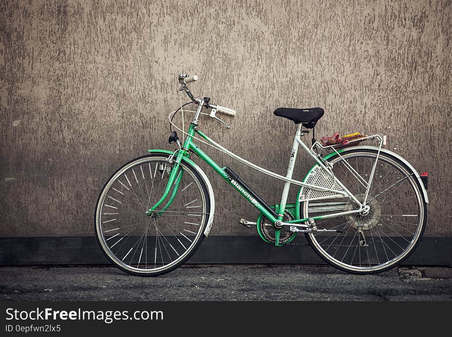 Green bicycle leaning against exterior wall. Green bicycle leaning against exterior wall.