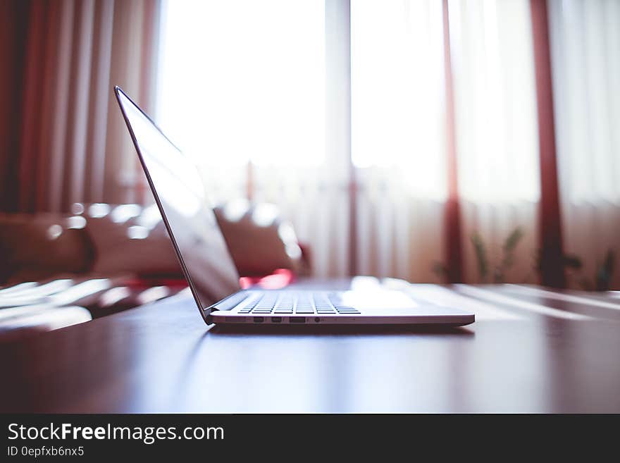 White Laptop Computer on Brown Wooden Table