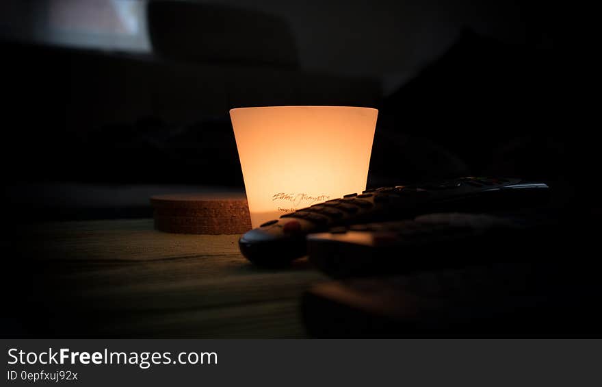 Black Remote Control Near Lamp Inside Dark Room