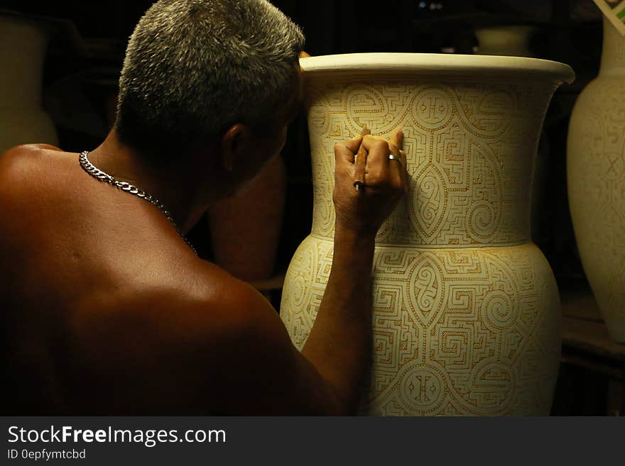 Close up of artist hand engraving ceramic vase. Close up of artist hand engraving ceramic vase.