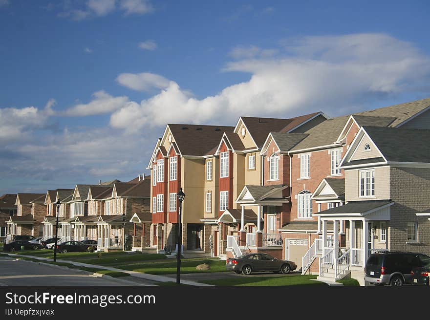 Residential neighborhood with green lawns against sunny blue skies.