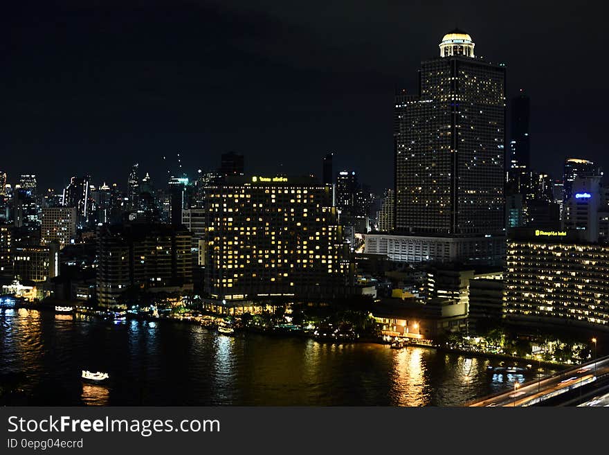 City skyline illuminated at night reflecting in waterfront. City skyline illuminated at night reflecting in waterfront.