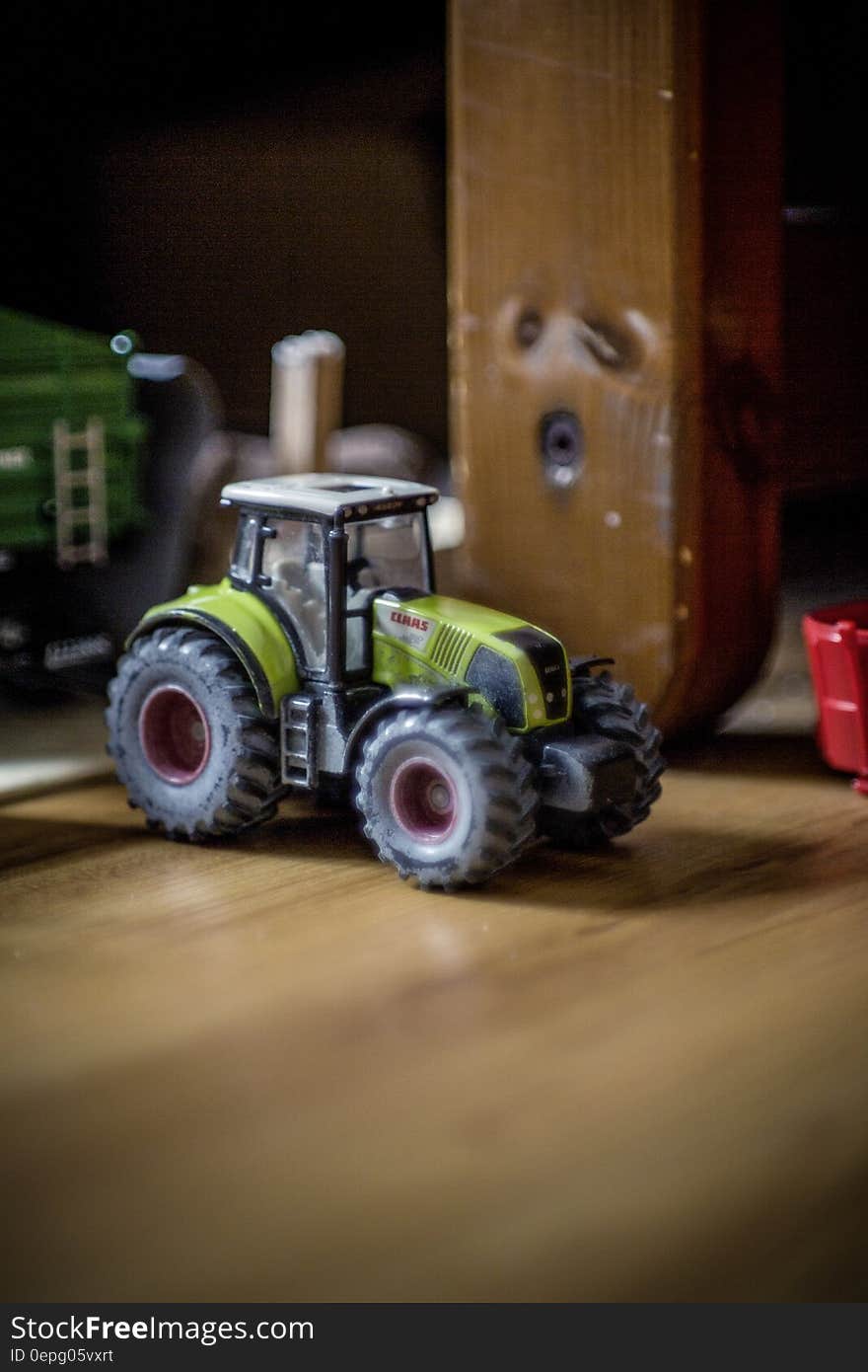 Close up of plastic toy tractor in room.