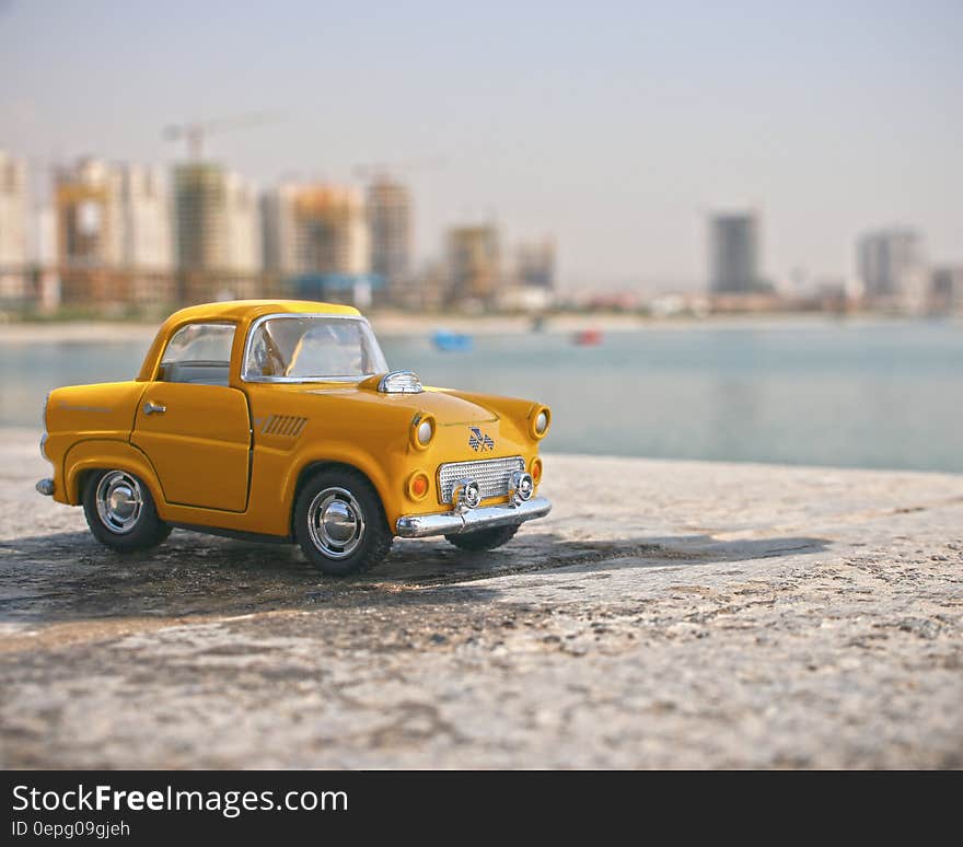 Miniature taxi cab photo with water and skyscrapers in the background. Miniature taxi cab photo with water and skyscrapers in the background.