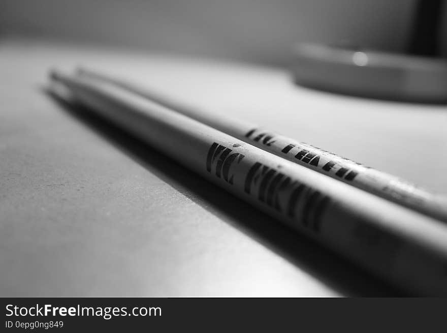 Close up of drumsticks resting on drum in black and white. Close up of drumsticks resting on drum in black and white.