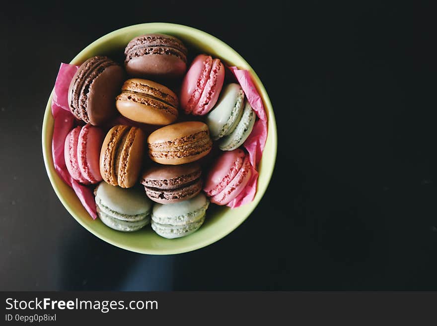 Green china bowl of colorful macaroons on black. Green china bowl of colorful macaroons on black.