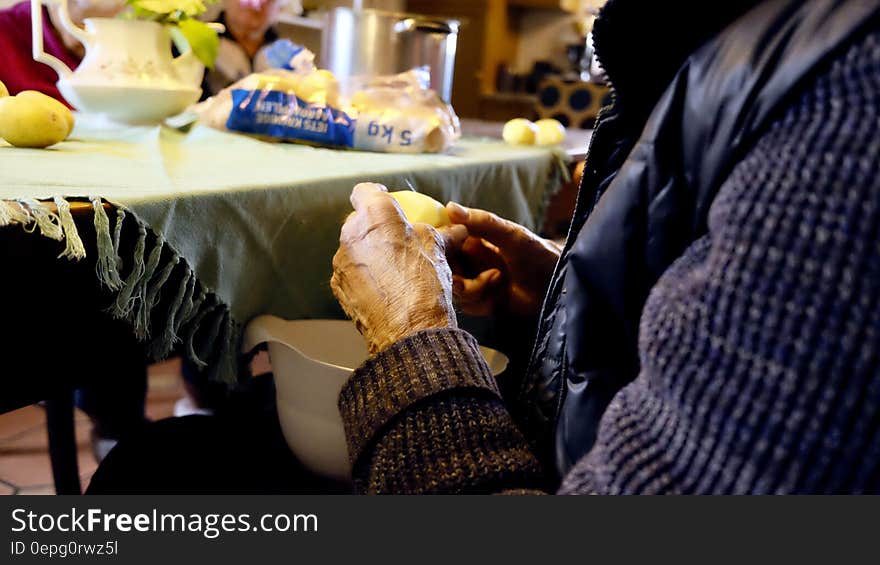 Person in Black and Purple Jacket in Front of Gray Table Mat